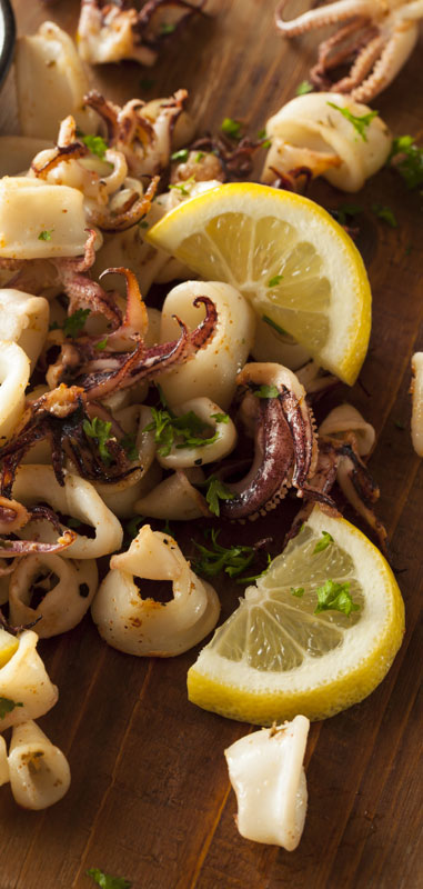 Grill calamari on a board with lemon.
